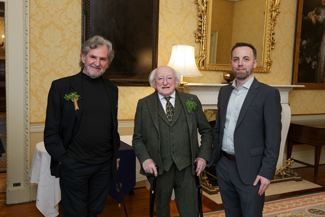 Three men, including the President of Ireland, Michael D Higgins, stand together in a large ornately decorated room