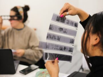 Two women look at photograph negatives
